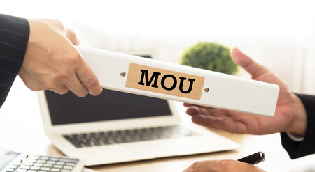 A hand reaches for a folder entitled 'MOU'